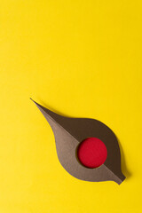 abstract shape with red circle motif on bright yellow paper