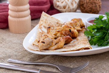 chicken kebab with tomato sauce and red onion on white plate
