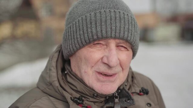 Caucasian white elderly man close up portrait on winter sunny day. Trekking active lifestyle male on retirement. Handheld video
