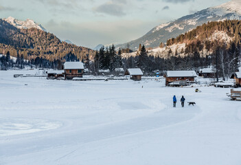 walking dog on frozen alpine lake Weissensee 