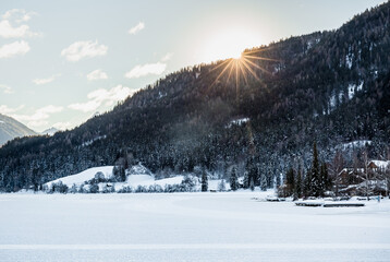 sunrise over frozen Weissensee lake in Austria