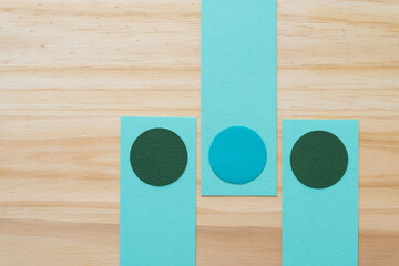 three paper circles on rectangles and wood