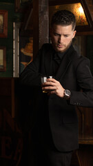 well-dressed young guy with glass of whiskey in hand