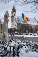  Evangelical Church Tower  in Bistrita , january 2022,and the flag of Romania ,view from Nicolae  Titulescu street