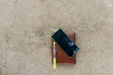 photo of notebook and smartphone on concrete table top view