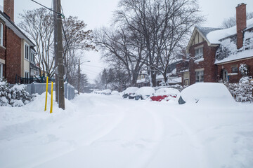 Toronto, Ontario / Canada - January 17, 2022 - Toronto St Clair West sideroad with cars covered on day of snowstorm