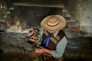 Mate in a traditional calabash gourd, dried leaves of yerba mate. Gaucho with boiler with hot...