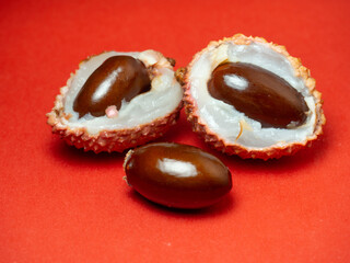 Sliced ​​lychee. Round pimply fruits. Chinese plum. Fruit peel. Peeling the lychee. Pieces of juicy fruit on a bright background.