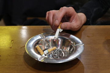 Fototapeta na wymiar 灰皿にタバコの灰を落とす手