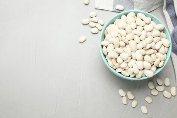 Raw white beans on light grey table, flat lay. Space for text