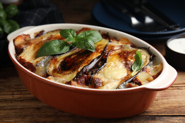 Delicious eggplant lasagna in baking dish on wooden table, closeup