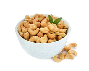 Bowl, tasty organic cashew nuts and green leaves isolated on white