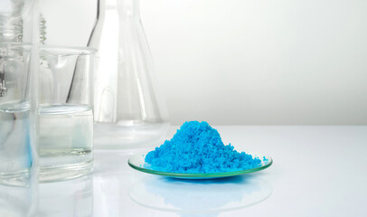 Closeup inorganic chemical on white laboratory table. Copper(II) sulfate in Chemical Watch Glass...
