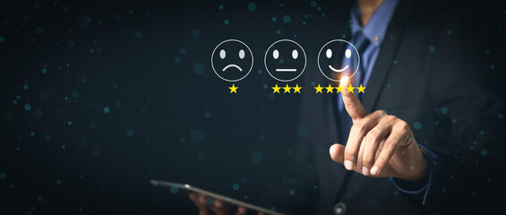 Customer Service and Satisfaction Concept Businessmen touch the virtual screen on happy smiley icons to achieve service satisfaction and feedback with excellent rated reviews.