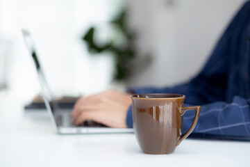 Hand of business man working from home using laptop computer to internet online on desk, lifestyle of new normal, social distancing, freelance work in stay home, employee using notebook indoor.