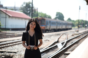 Fototapeta premium young asian woman smilingTraveler girl walking and waits train on railway platform