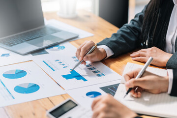 Teamwork process, business people working pointing graph discussing documents and ideas at meeting.