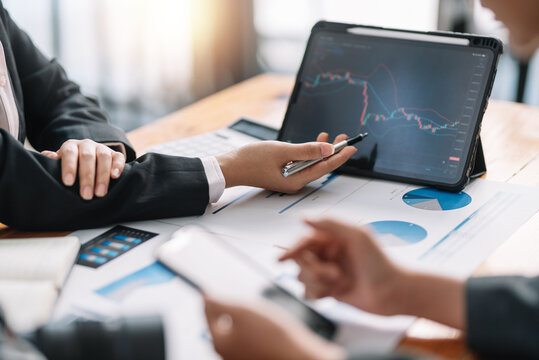 Investor team analyzes the stock market on a tablet at the meeting.