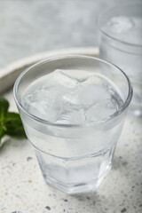 Glasses of soda water with ice and mint on marble tray, closeup