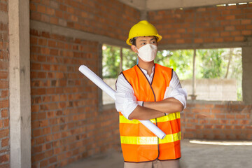engineer concept The male engineer standing in the building and looking at many workers doing their job