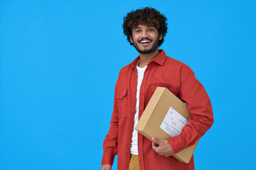 Happy indian young man customer or courier holding parcel box isolated on blue background. Smiling...