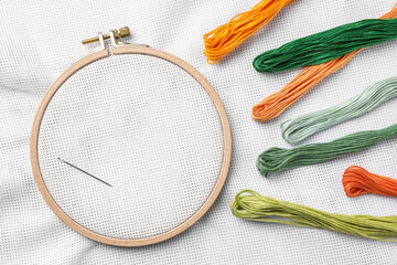 Threads near embroidery hoop with white fabric, flat lay © New Africa