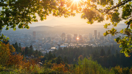 Portland Downtown and Mt Hood Framed with Maple leaves and other autumn foliage, Rising sun shining behind the leaves.