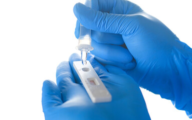 Hand of doctor drops reagent onto coronavirus (Covid 19) antigen test kit, medical concept, and...