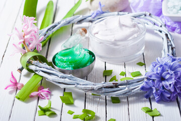 cosmetic cream product samples with hyacinth flowers on white wooden background