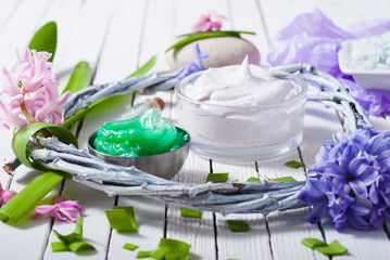 cosmetic cream product samples with hyacinth flowers on white wooden background