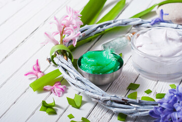 cosmetic cream product samples with hyacinth flowers on white wooden background
