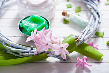 cosmetic cream product samples with hyacinth flowers on white wooden background