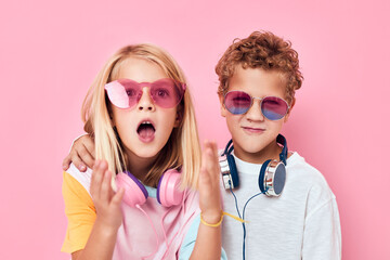 trendy boy and girl entertainment headphones playing pink color background