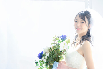 かわいいアジア系（日本人）花嫁さんのイメージ　左にコピースペースあり　カメラ目線