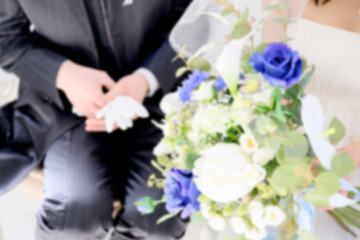  結婚式のイメージで背景に使いやすいブーケと新郎新婦のイメージのぼかし（ボケている）写真