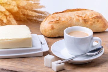 Breakfast, coffee mug, butter dish and bread in the background