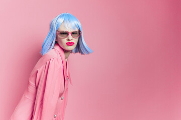 woman in sunglasses wears a blue wig makeup pink background