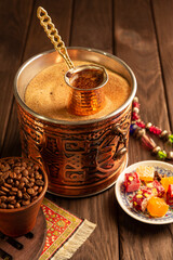 Traditional Turkish coffee in cezve prepared on hot sand in authentic brass Turkish Copper.