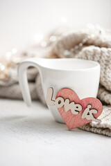 Cozy composition for Valentine's Day with a cup and decor details.
