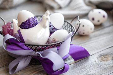 Easter composition with eggs, decorated with purple sparkles.