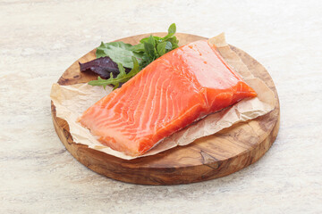 Raw salmon fillet over board