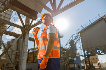 Fototapeta premium Experienced worker standing in front of large construction plant