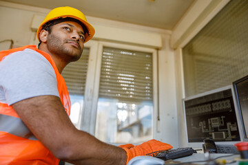 Young multiethnic operator working at construction plant