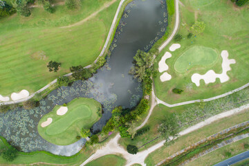 Aerial view drone shot of beautiful green golf field fairway and putting green Top down image for sport background and travel nature background Amazing view
