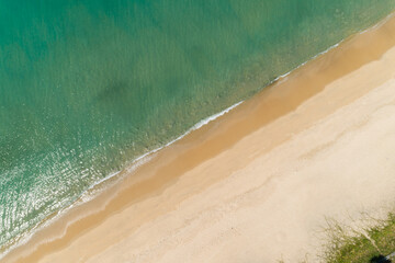 Aerial view sandy beach and waves Beautiful tropical sea in the morning summer season image by Aerial view drone shot, high angle view Top down sea waves