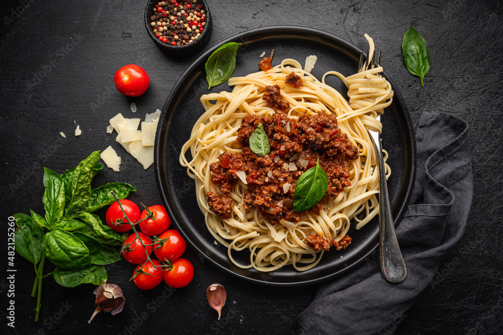 Poster pasta spaghetti bolognese with minced beef sauce, tomatoes, parmesan cheese and fresh basil in a pla