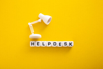 Word of Helpdesk with Table lamp on yellow background