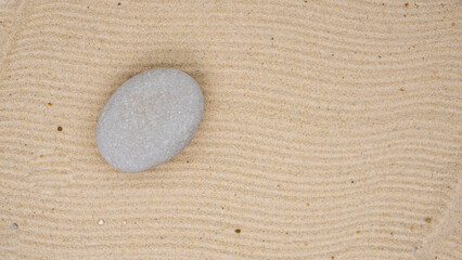 Fototapeta na wymiar zen stone on sand surface with copy space