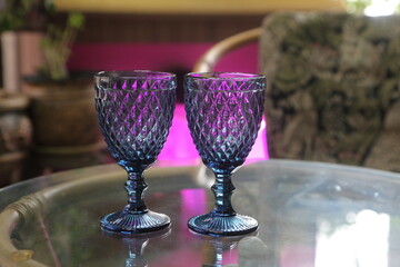 Two blue glasses on a glass table