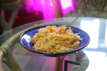Stewed cabbage in a blue ceramic plate on a glass table